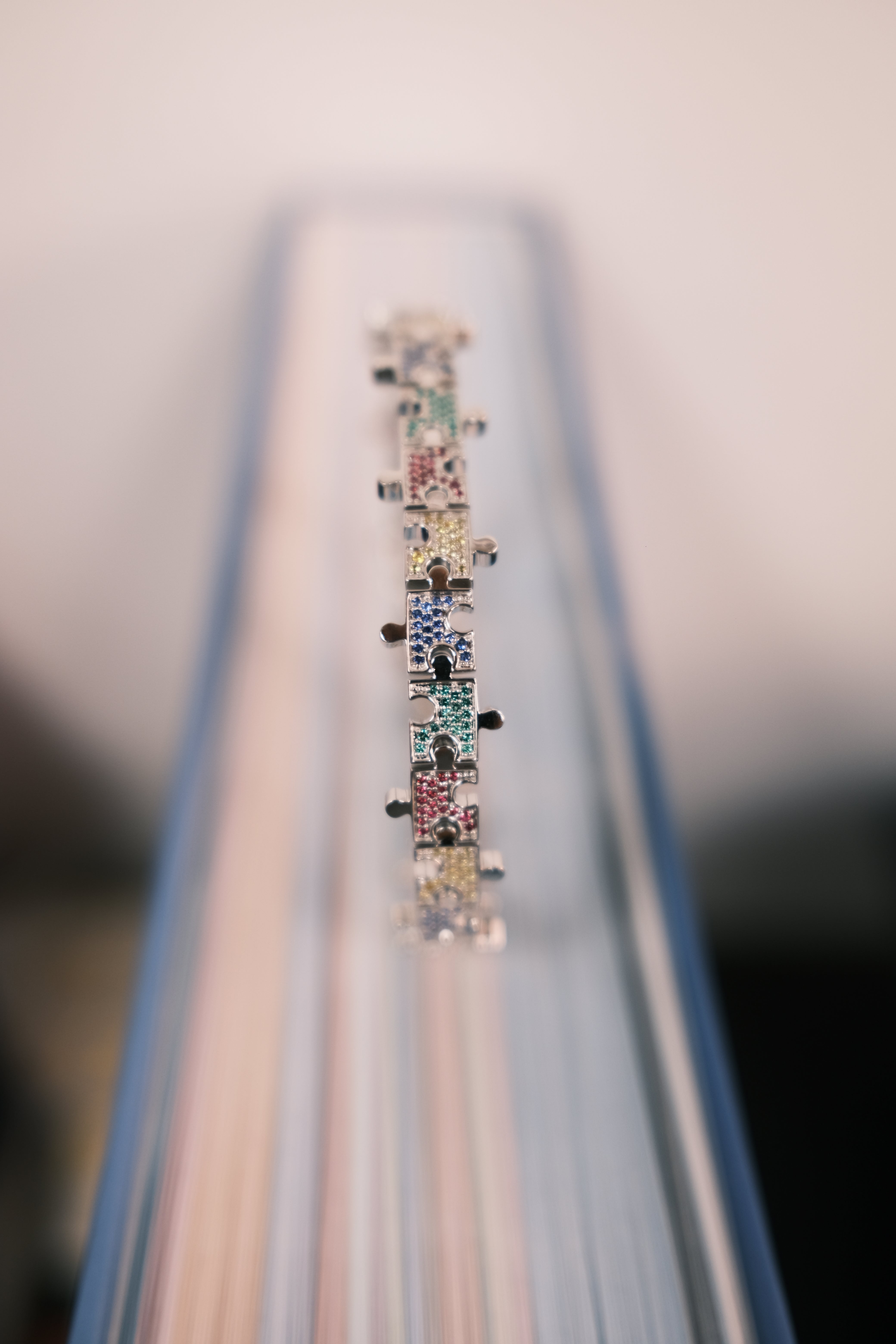 JW Multicolored Puzzle bracelet on a book 2