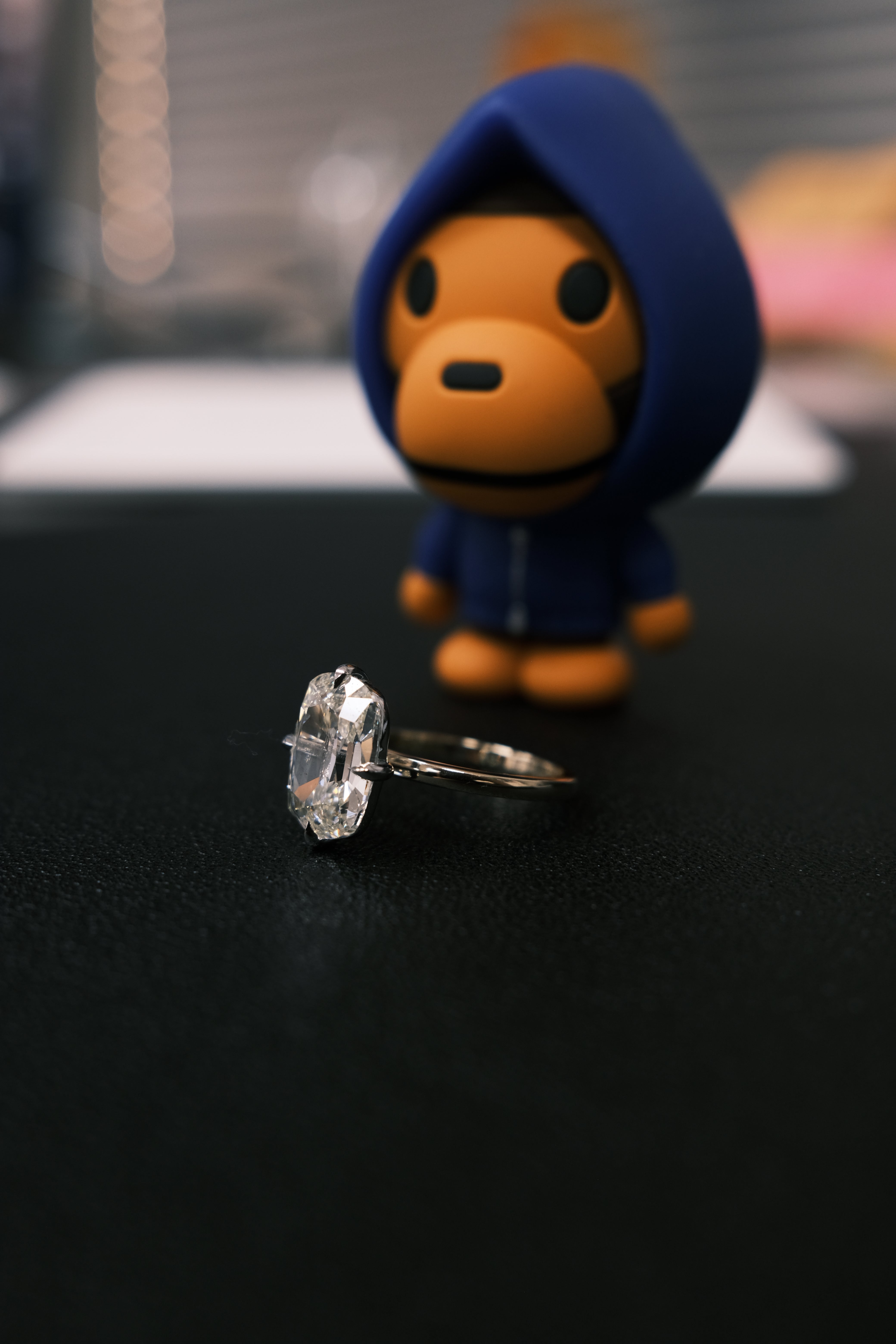RO Solitaire Engagement Ring with a toy figure in the foreground