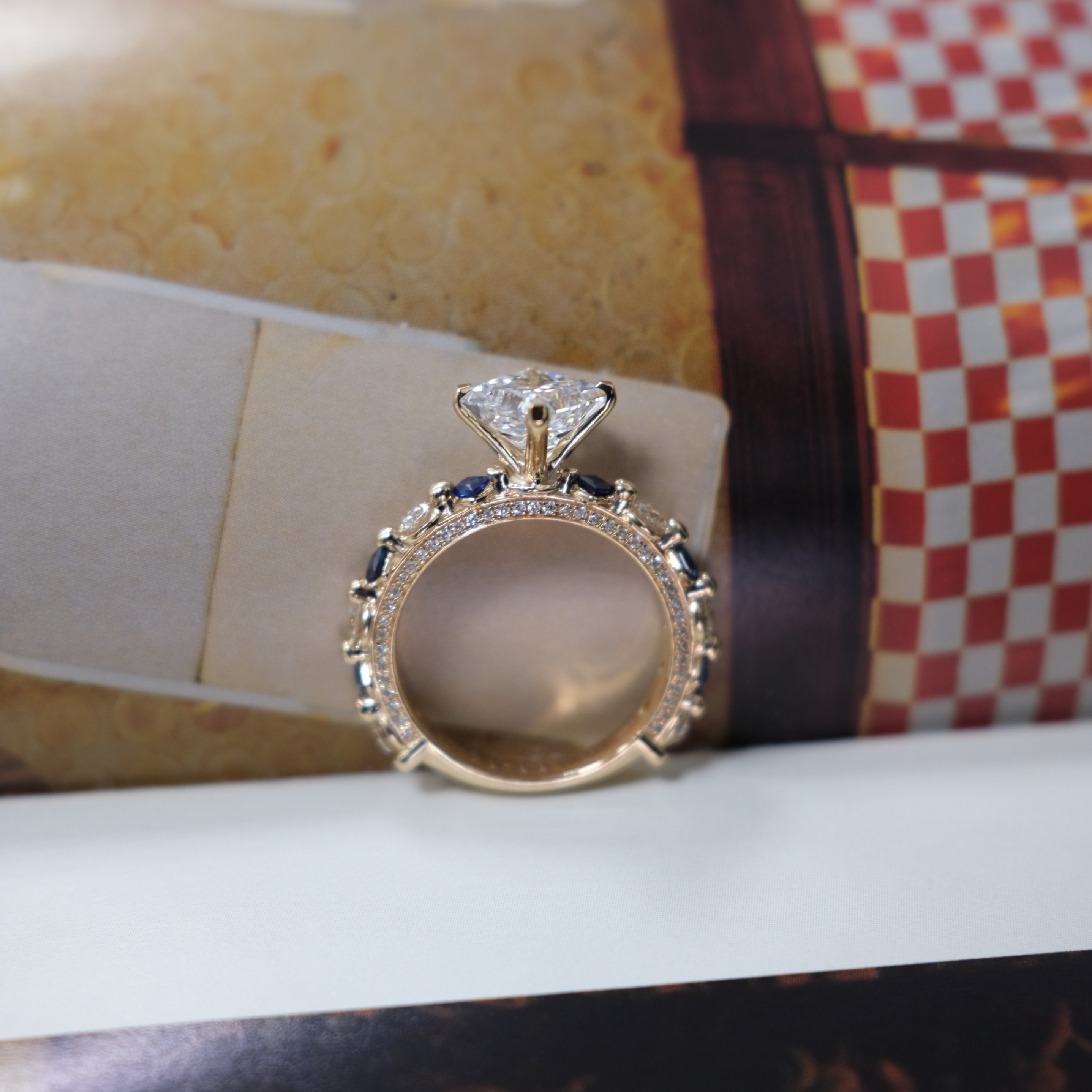 JA Diamond Solitaire ring resting on a magazine